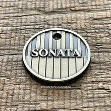 Load image into Gallery viewer, Personalised piano keys dog ID tag deeply engraved into brushed nickel silver metal with raised Sonata name and vertical keyboard pattern on rustic wood background