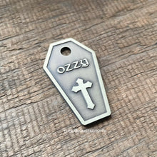 Load image into Gallery viewer, Dog ID tag shaped like a coffin with cross design deep engraved on metal tag, personalised engraved gothic pet tag with the name Ozzy.