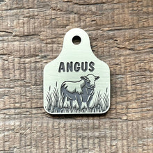 Load image into Gallery viewer, Dog ID tag shaped like a livestock ear tag with cow design deep engraved on metal tag, personalised engraved pet tag with the name Angus