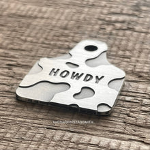 Load image into Gallery viewer, Dog ID tag shaped like a cattle ear tag with cow print pattern and engraved name Garrett, personalised deep engraved metal pet tag.
