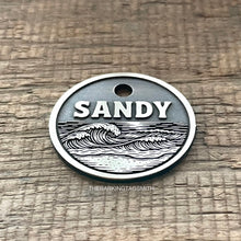 Load image into Gallery viewer, Dog ID tag with ocean wave design deep engraved on round metal tag, personalised engraved pet tag for beach lovers with the name Sandy