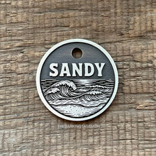 Load image into Gallery viewer, Dog ID tag with ocean wave design deep engraved on round metal tag, personalised engraved pet tag for beach lovers with the name Sandy.