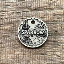 Load image into Gallery viewer, Personalised pirate treasure map dog ID tag with engraved sailing ship, skull island, treasure chest and map trail design in brushed silver metal on rustic wood background
