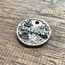 Load image into Gallery viewer, Personalised pirate treasure map dog ID tag with engraved sailing ship, skull island, treasure chest and map trail design in brushed silver metal on rustic wood background