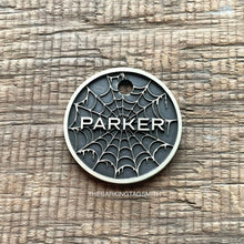 Load image into Gallery viewer, Personalised spider web dog ID tag with engraved gothic web pattern and raised Parker name in brushed silver metal on rustic wood background