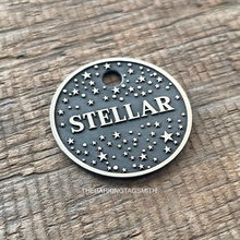 Load image into Gallery viewer, Dog ID tag with starry night sky pattern deep engraved on round metal tag, personalised engraved pet tag with the name Stellar.