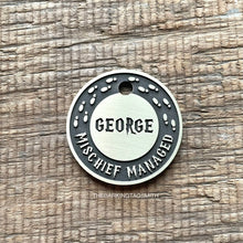 Load image into Gallery viewer, Personalised wizard map dog ID tag with engraved magical footprints and fantasy-inspired lettering in brushed silver metal on rustic wood background