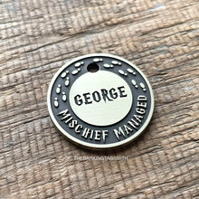 Load image into Gallery viewer, Personalised wizard map dog ID tag with engraved magical footprints and fantasy-inspired lettering in brushed silver metal on rustic wood background